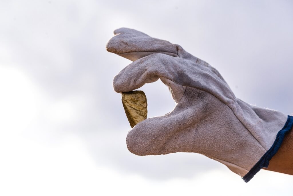 Gloved hand holding a gold nugget linked to illegal mining